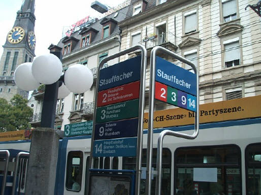 TRAMHALTESTELLE STAUFFACHER. Mit 3er Tram. VBZ Zri-Linie. Tram Nummer 3, Modell Tram 2000. Links im Bild die Kirche St. Jakob am Stauffacher.